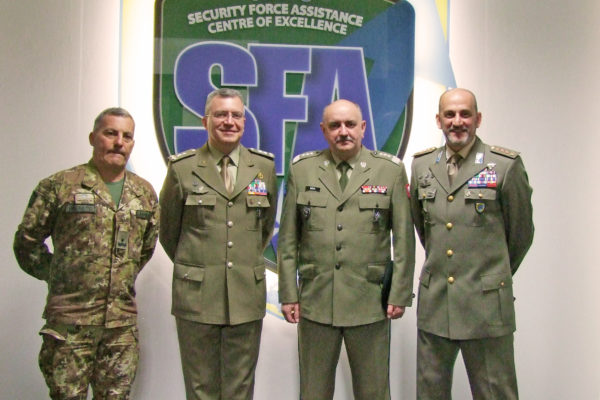 Photo in front of the NATO SFA COE logo
